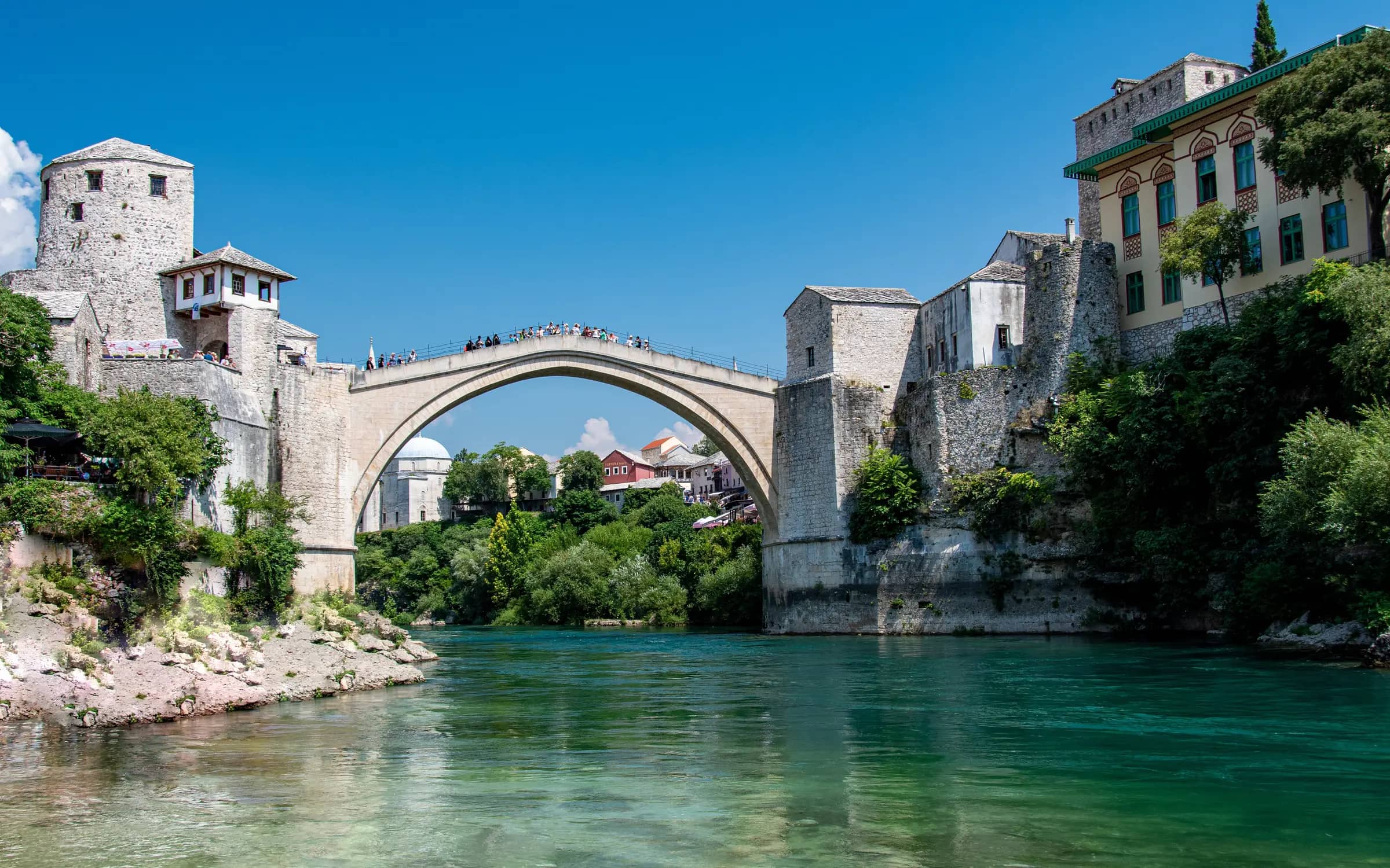 Stari Most, the Old Bridge in Mostar, over the green Neretva river on a clear day